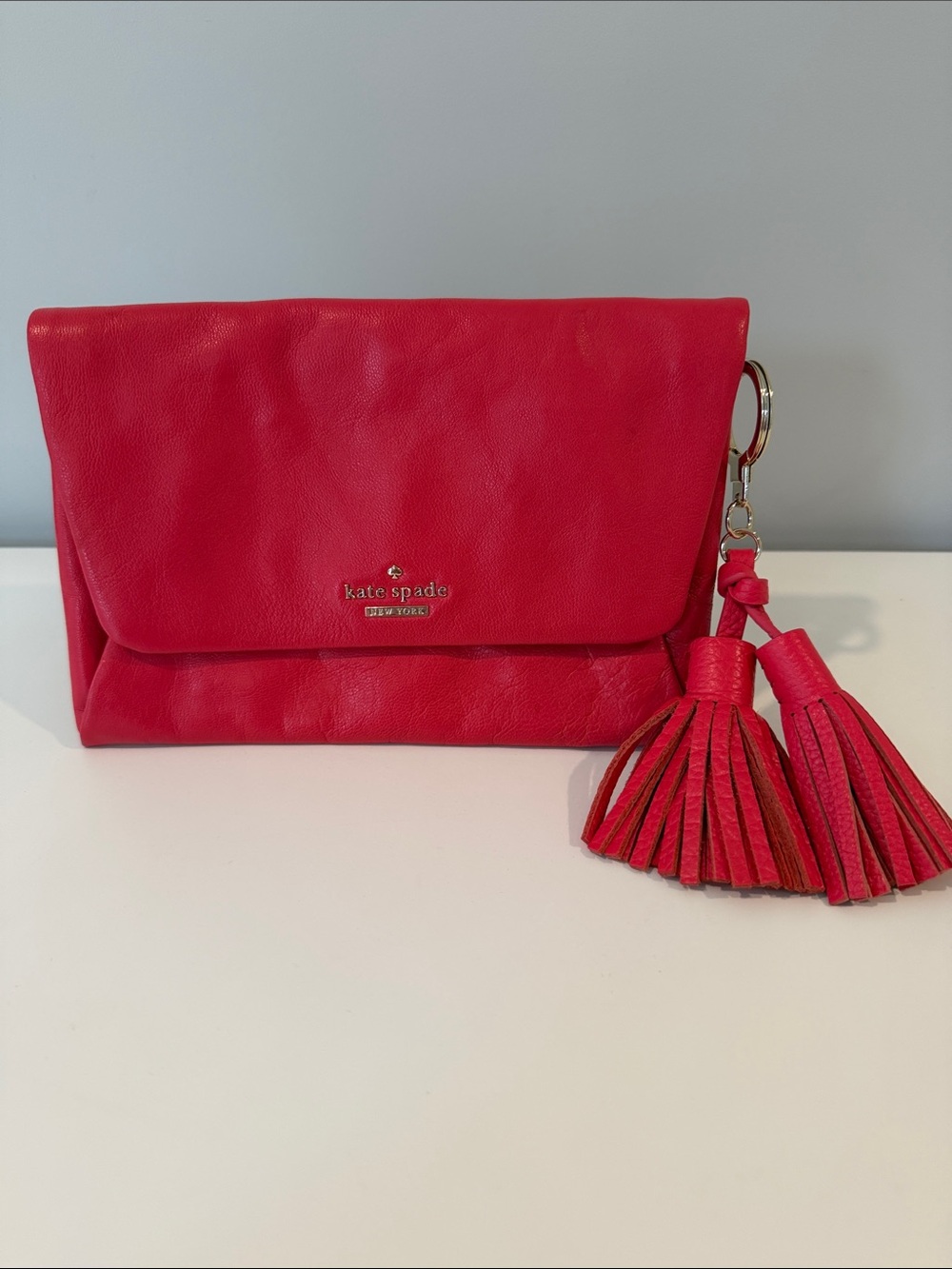 kate spade coral pink leather fold-over clutch with tassel charm